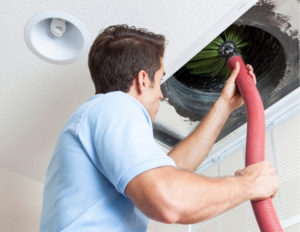 Technician cleaning airduct