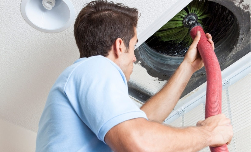 Technician cleaning airduct